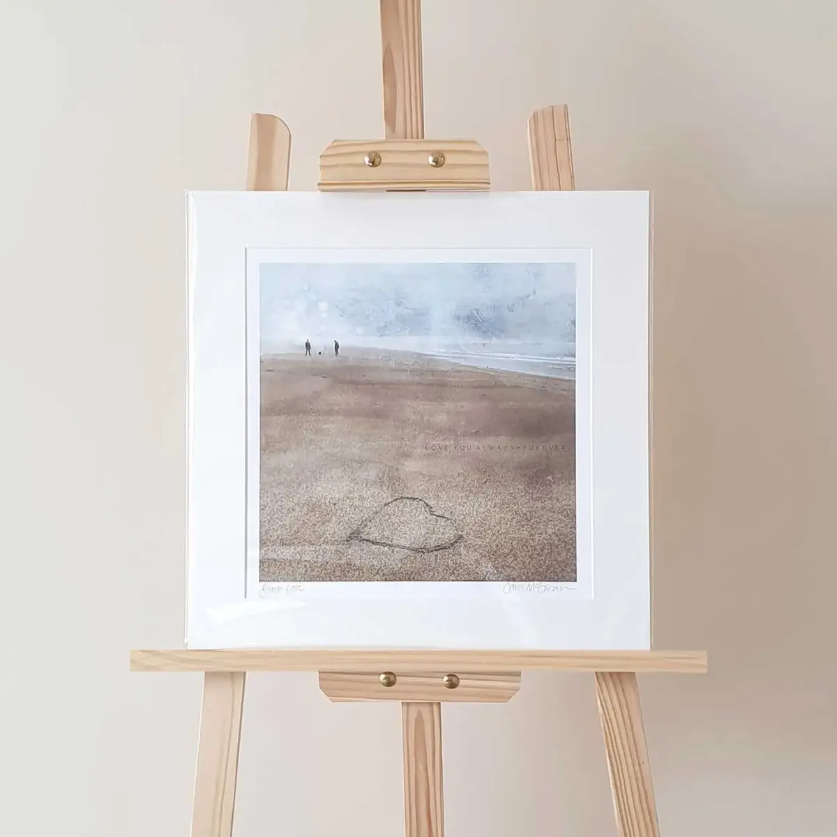 Beach Walk Mounted Print sat on an easel. The print has neutral beige and blue colours.