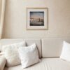 Queensferry print in a frame on a living room wall with cream walls & sofa