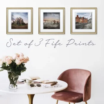 set of 3 Fife art prints hanging in frames on a cream wall with a table and chair in front and some flowers