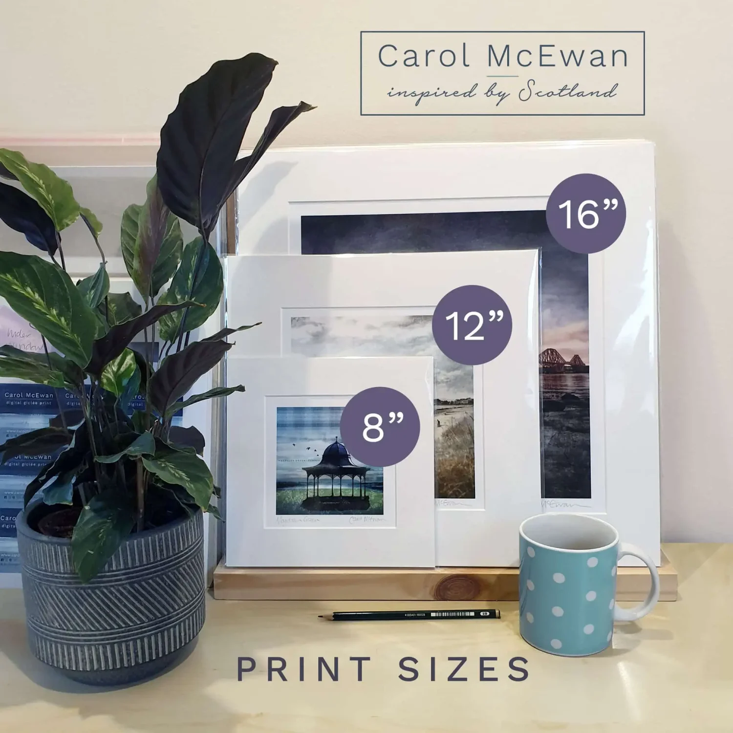 A photo of the 3 print sizes available for Carol McEwan Scottish Art Prints. A mug and a plant are next to them to show the scale of the 3 sizes - 8, 12 & 16"