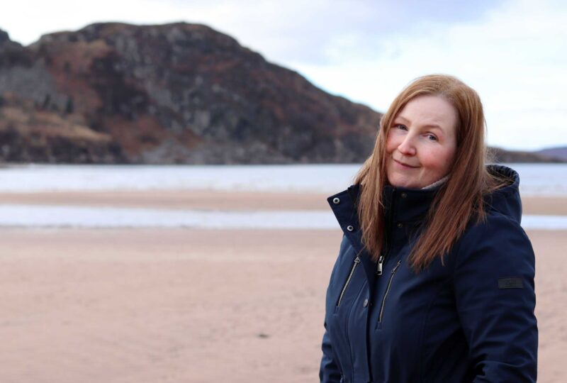 photo of artist Carol McEwan looking windswept and interesting on a Scottish beach!