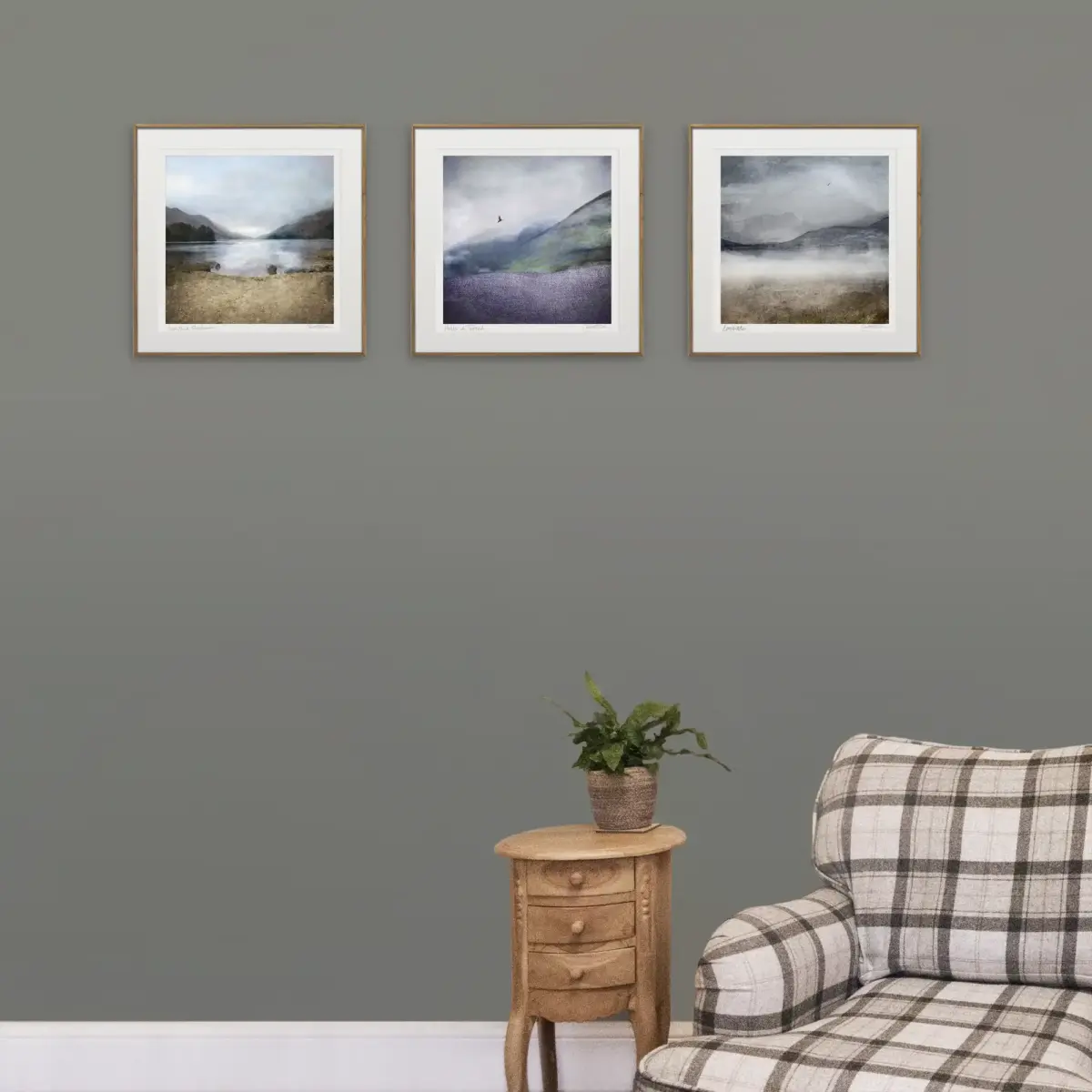 3 framed prints on a cream wall with a tartan chair and wee table to show how they would look in a living room