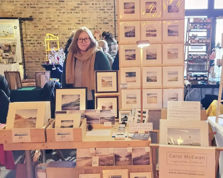 Carol at market stall, with all her prints on display