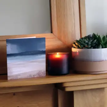 Rain Over Fife artist greetings card on mantletpiece next to candle and plant