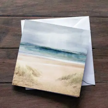beach printed greetings card on top of white envelope on wooden surface