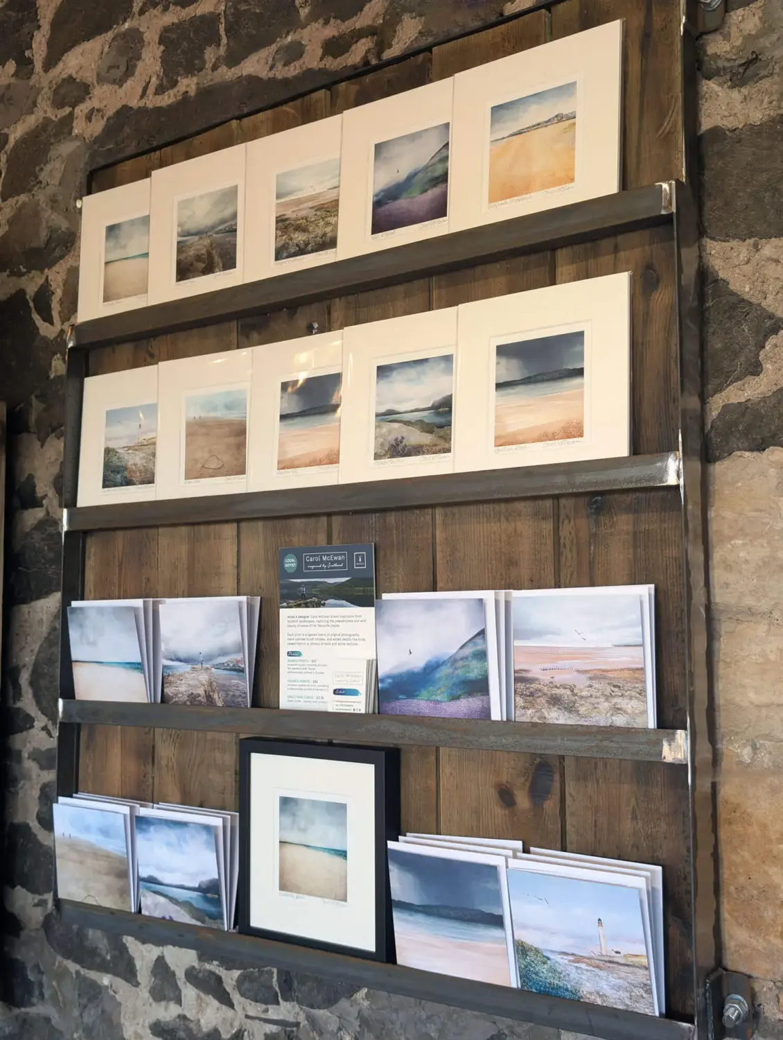 a range of Carol's 8x8" prints on display on wooden shelves at the Rhynd Café near Tenstmuir Beach