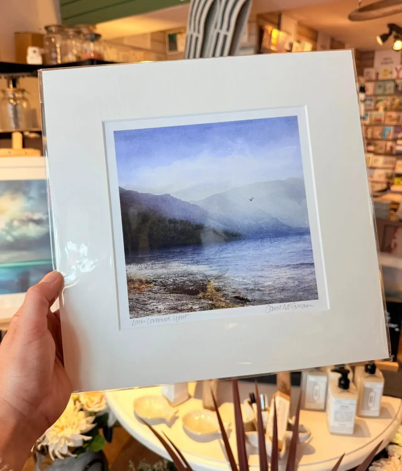 Loch Lomond art print being held by buyer in retail store